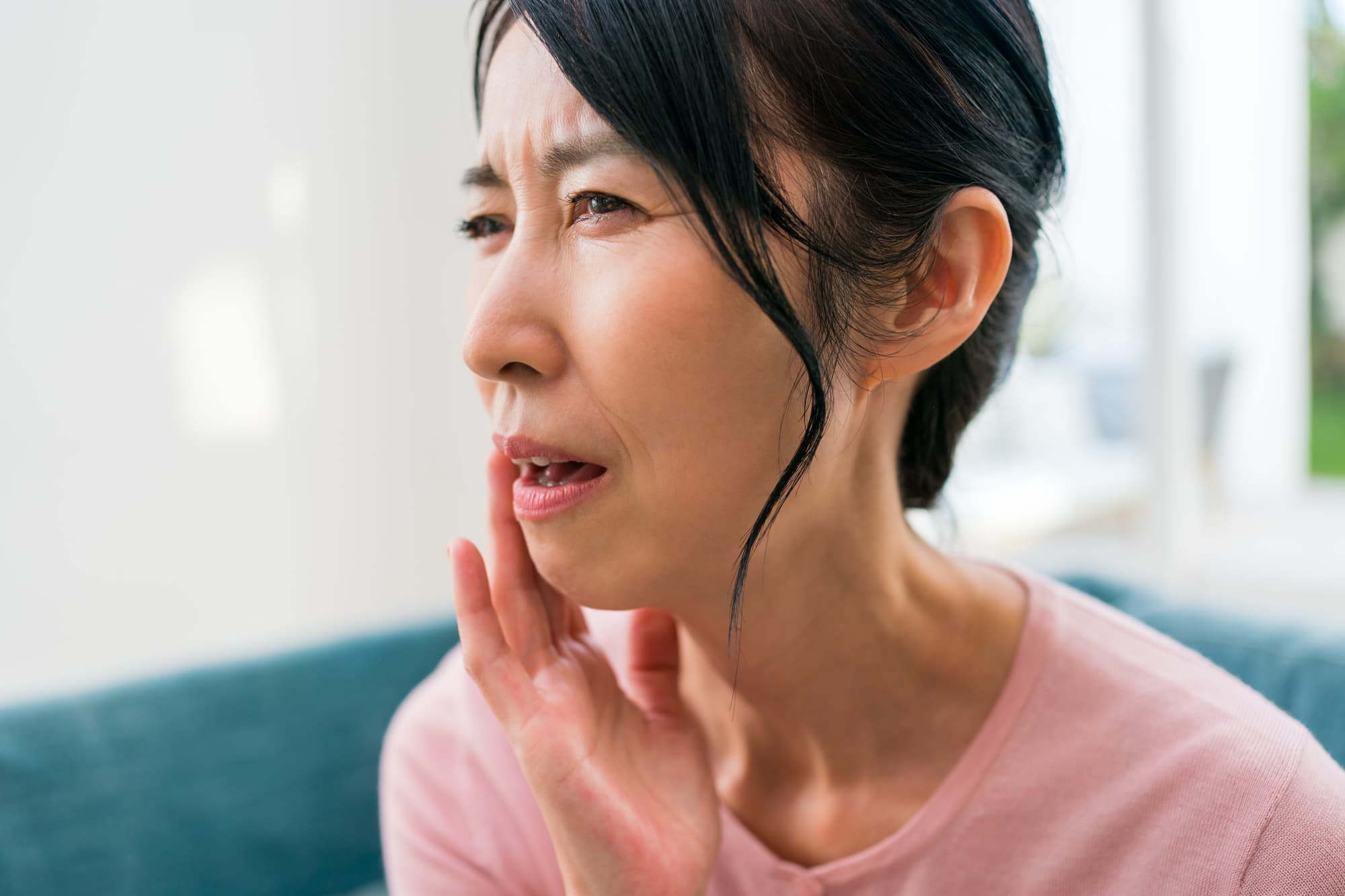 寿命を迎えたインプラントを使用して歯が痛くなった女性