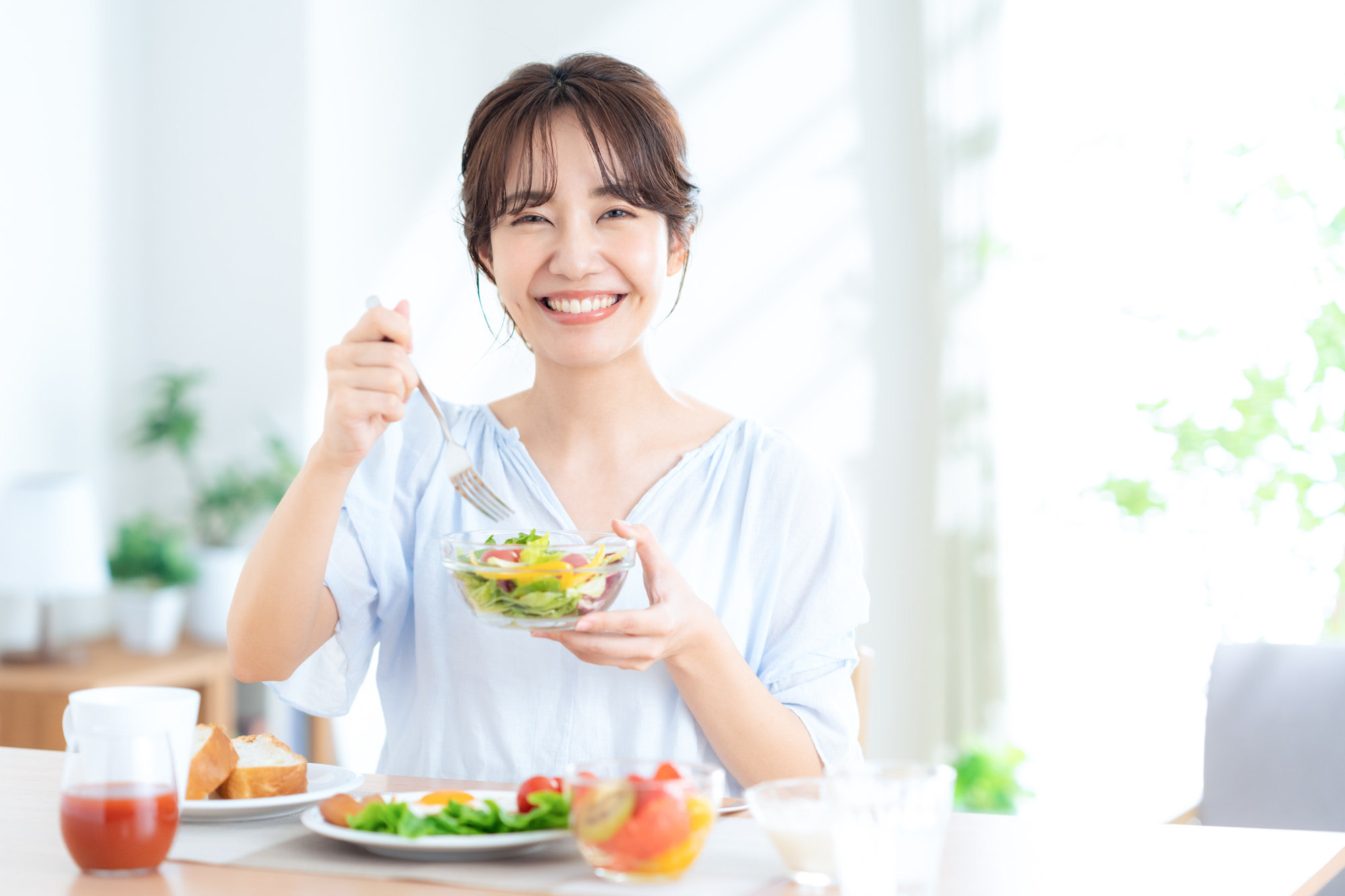 歯周病を治療し美味しく食事をいただく女性