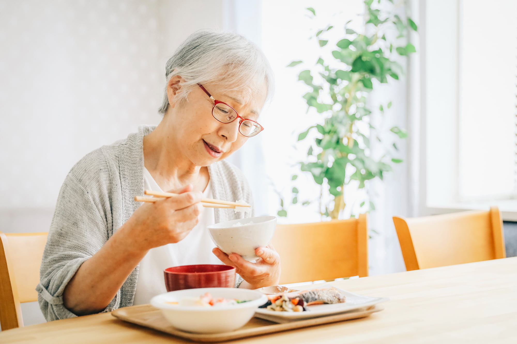 自分に合った入れ歯を装着し美味しく食事をいただく女性