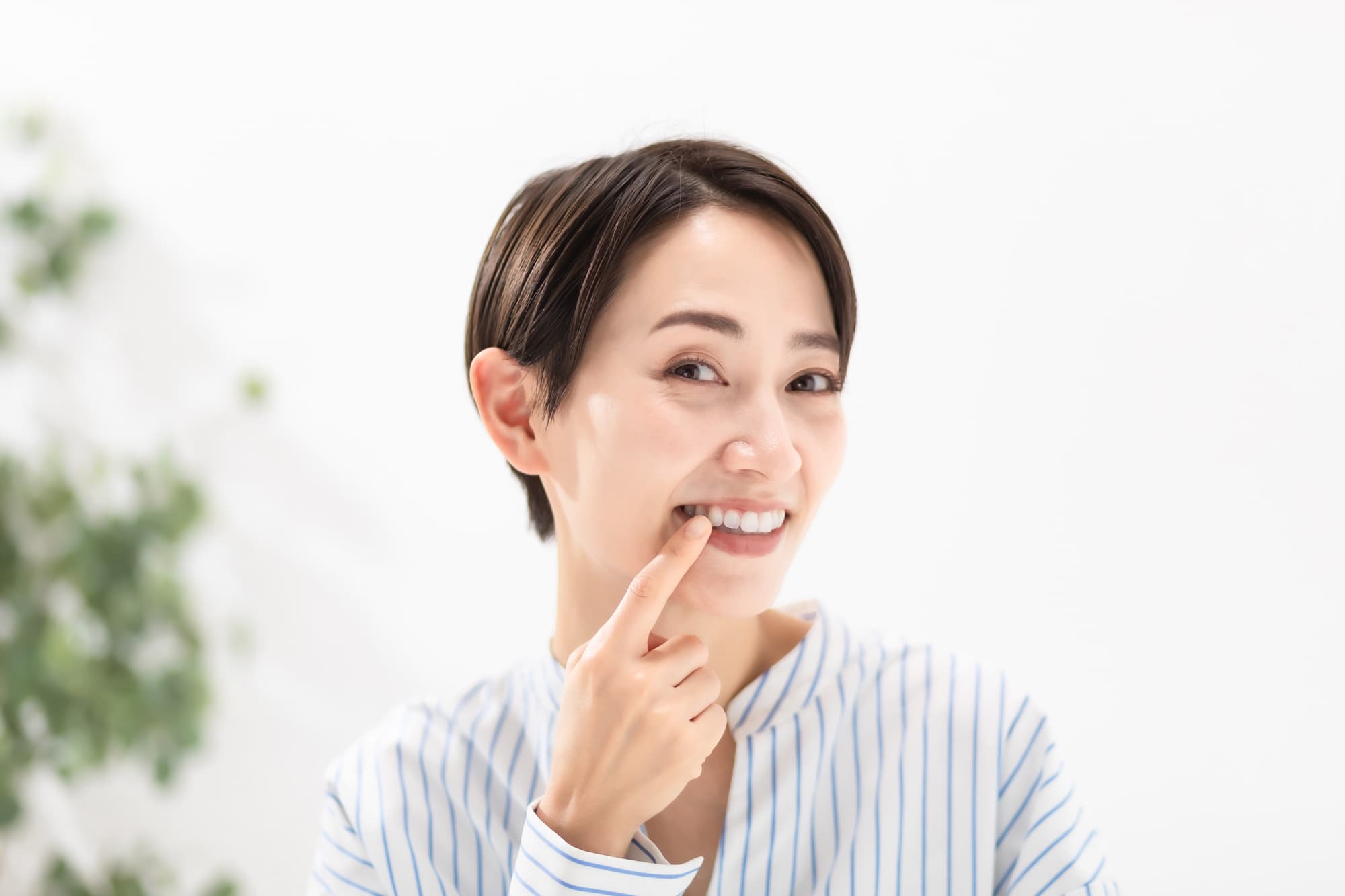 歯周病を治療した歯茎を指さす女性