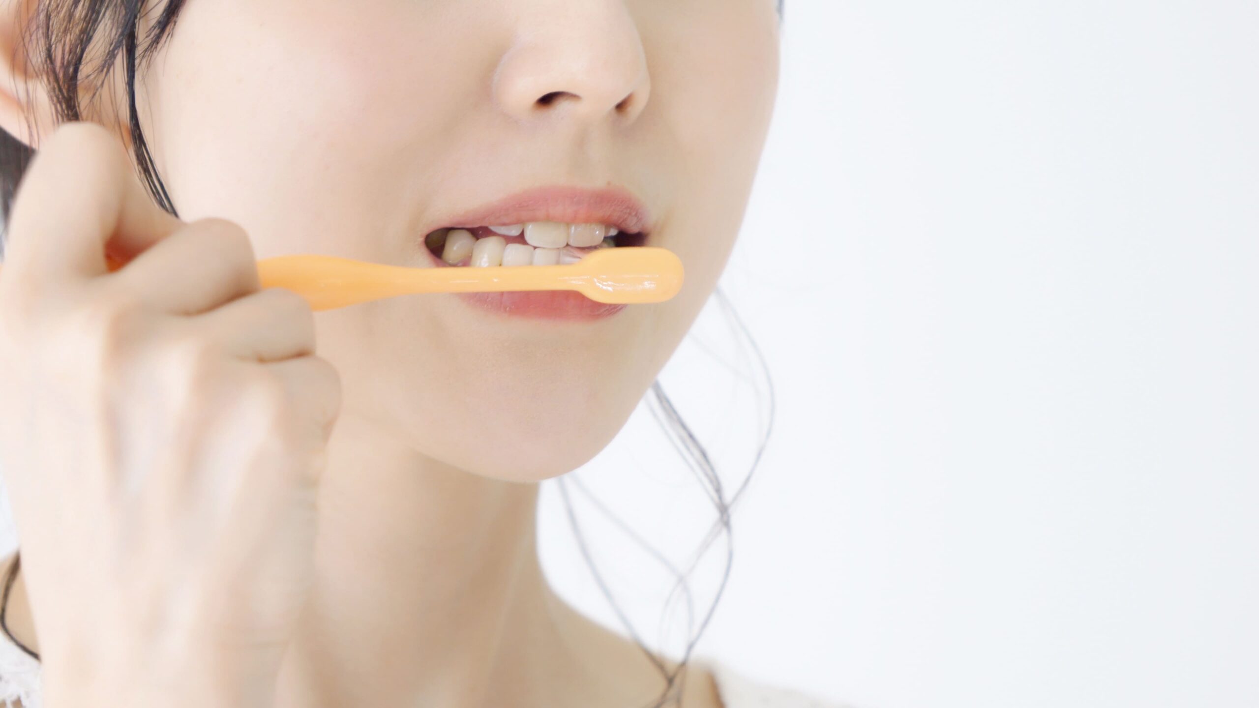 歯周病を予防するための正しい歯磨きをしている女性の口元
